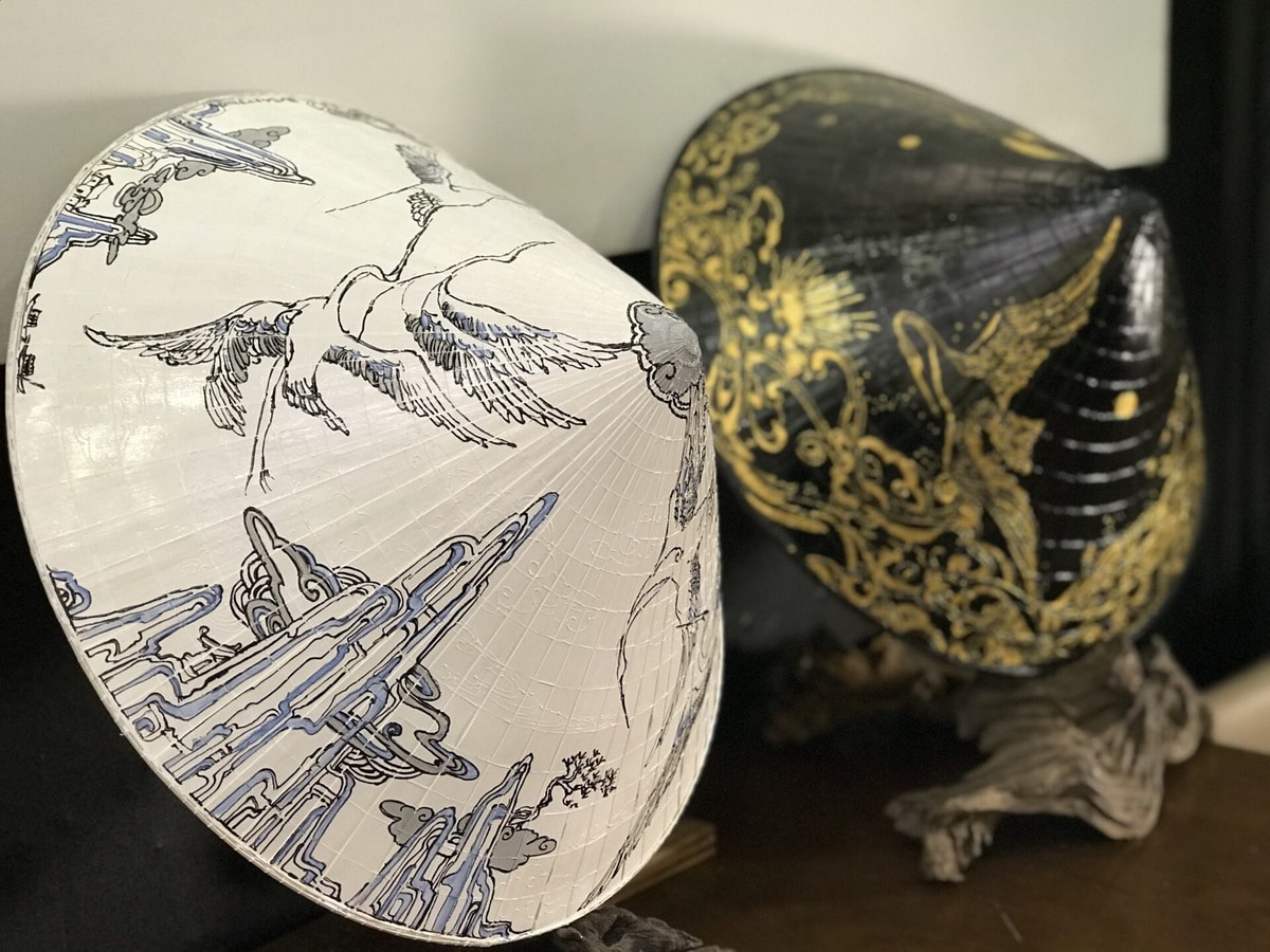 The conical hat is also stylized with intricate hand-embroidered details, adding a unique touch to this traditional Vietnamese item (